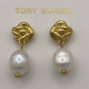 Tory Burch faux pearl drop from gold tone knot. Bottom of pearl has TB logo
